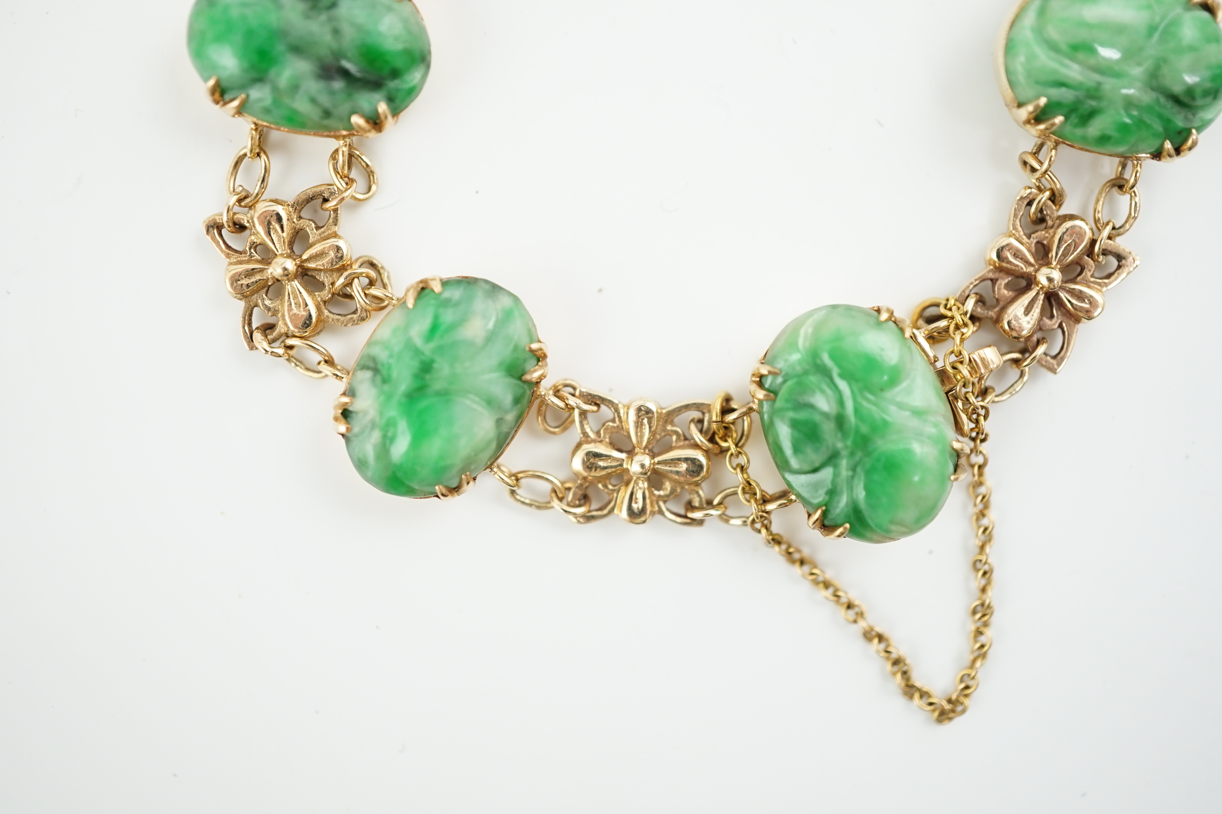 An early 20th century 9ct gold butterfly link and six stone carved jade set bracelet